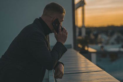 A man on his phone staring into the sunset