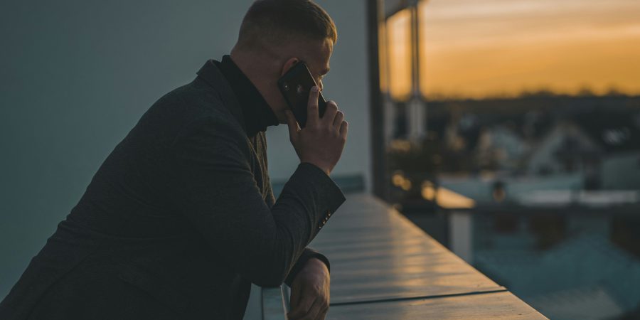 A man on his phone staring into the sunset