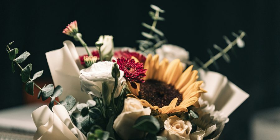 Image of flowers with black background - Watch out for obituary scams